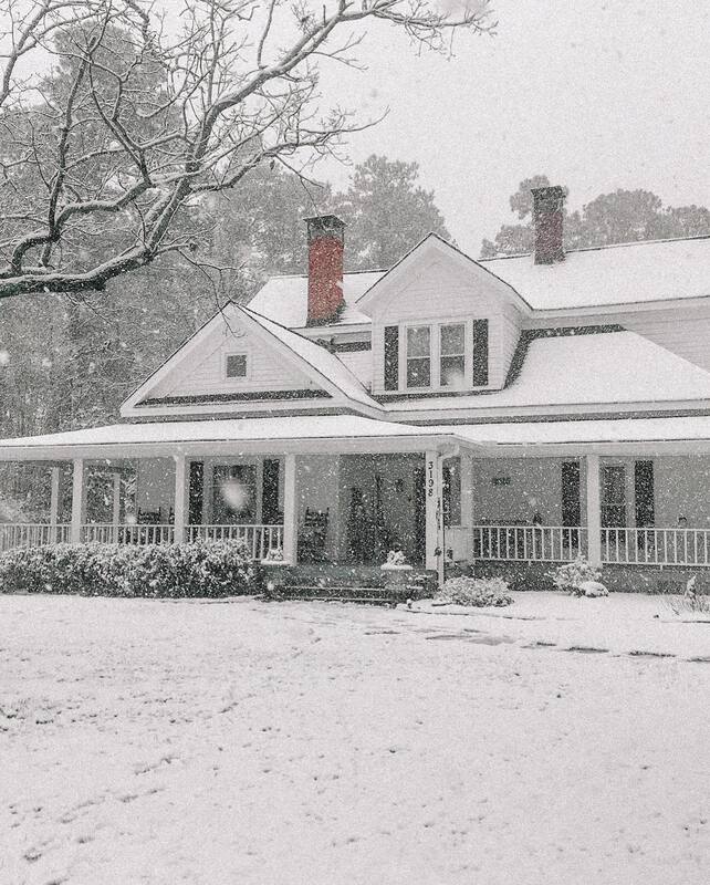 Four Oaks Manor farmhouse covered in snow