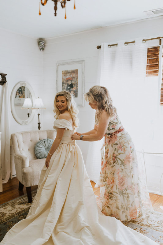 mother buttoning bride's vintage wedding gown
