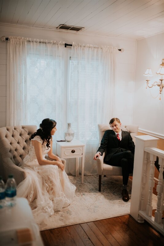 newlyweds sitting on chairs in farmhouse bridal suite