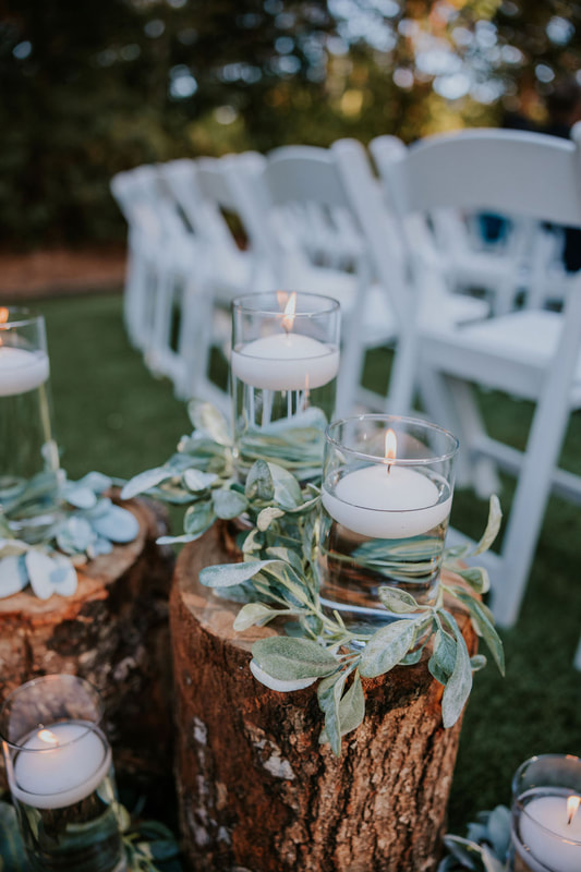 ceremony decor arrangement of stumps with floating candles and lambs ear
