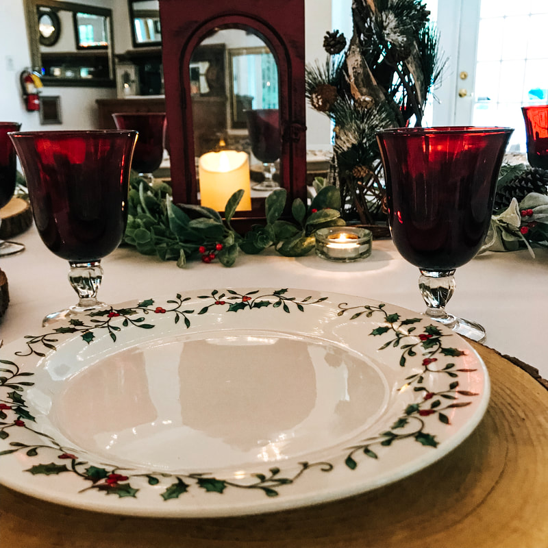 holly rimmed china on wood slice place setting