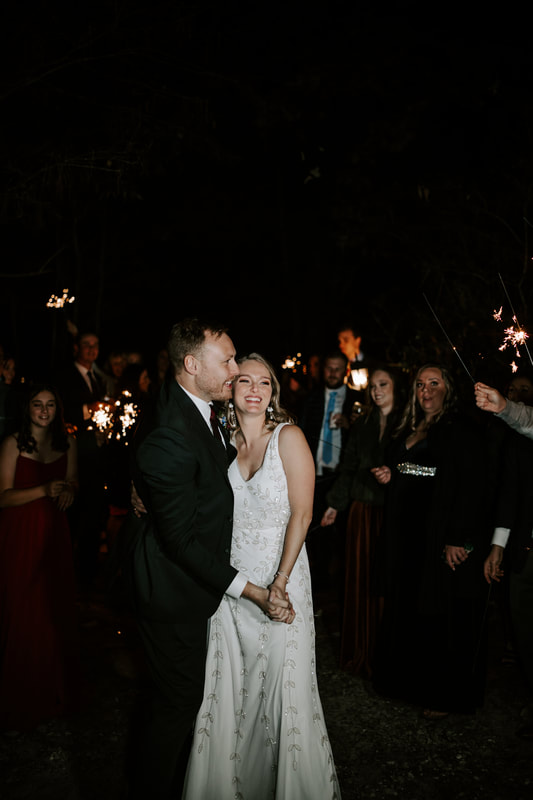 bride and groom smiling and hugging during sparkler grand exit