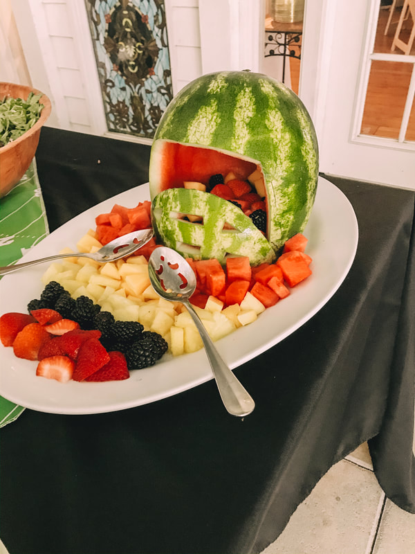 assorted fruit coming out of watermelon shaped like a football helmet