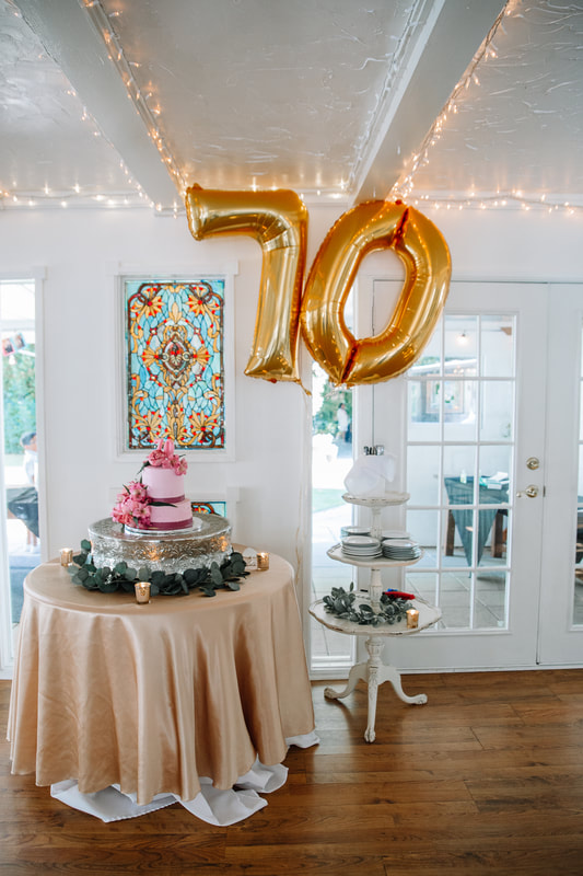 70th birthday cake table and giant gold balloons