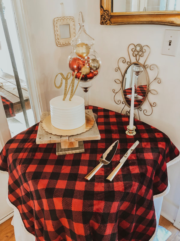 simple wedding cake with w cake topper on buffalo plaid overlay