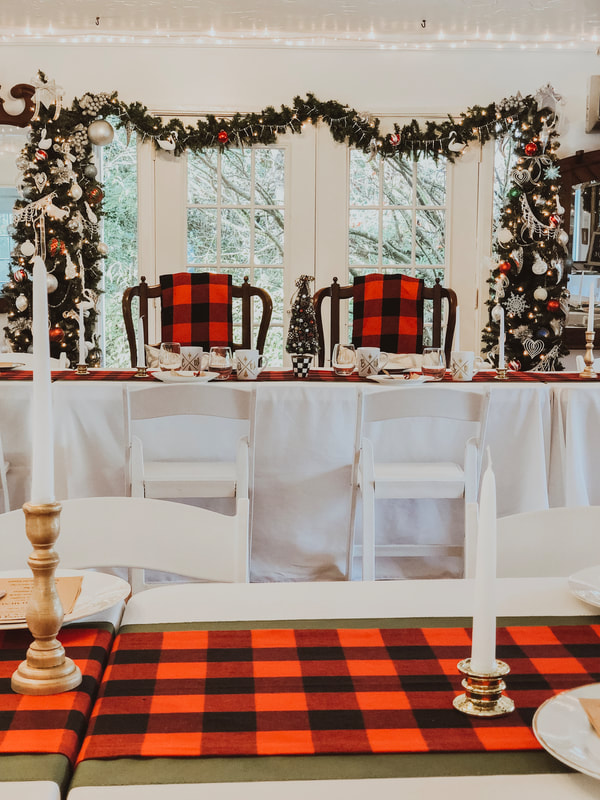 Christmas inspired head table with Mr and Mrs chairs decorated with buffalo plaid blankets
