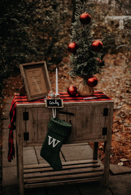 Christmas guest book table with buffalo plaid fabric, green stocking, and mini tree