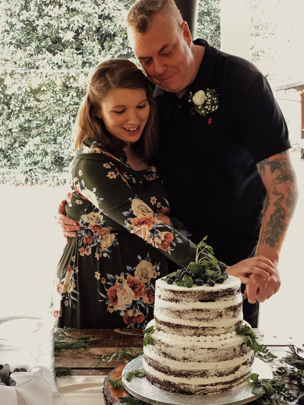 mom and dad to be cutting cake during baby shower