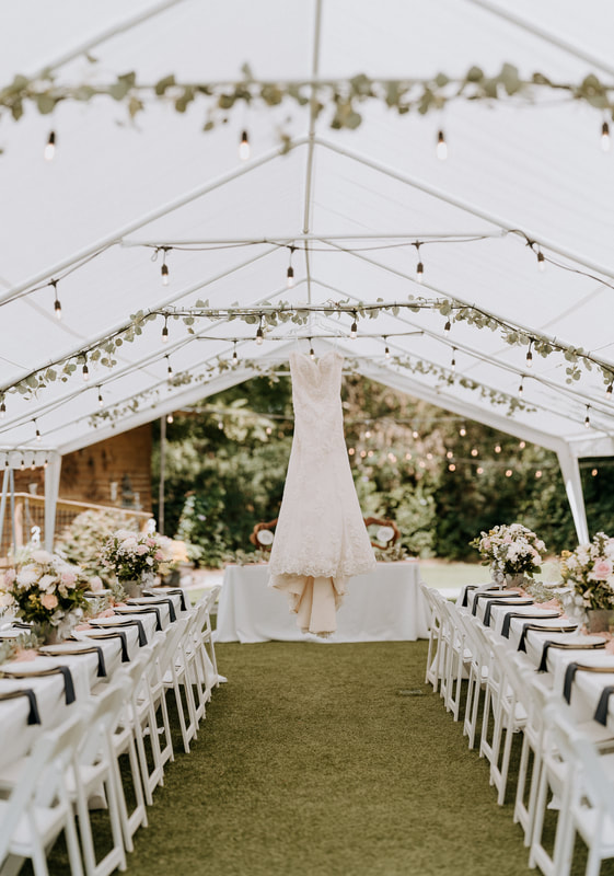 dress hanging on tent covering wedding reception