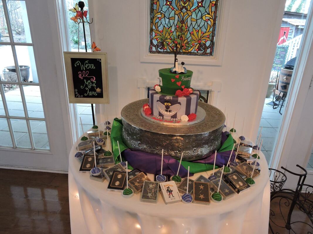 Picture of Rebecca's Alice in Wonderland Sweet 16 party. The cake was designed after the Mad Hatter and the Chesire cat, and is surrounded by cake pop and decks of cards for favors.