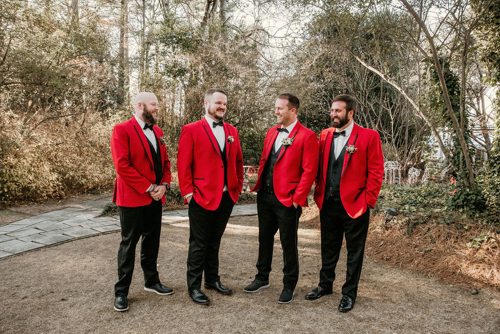 Groom and his groomsmen wearing red Christmas suits for December outdoor wedding. 