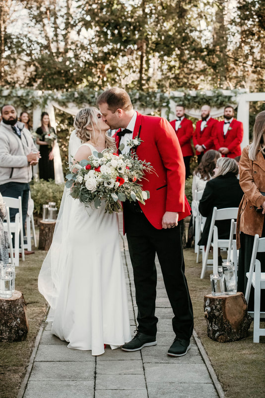 Bride and groom kissing at their outdoor wedding ceremony in December.