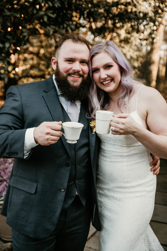 couple holding vintage coffee cups during outdoor wedding