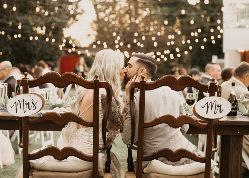 bride and groom kissing at garden wedding reception