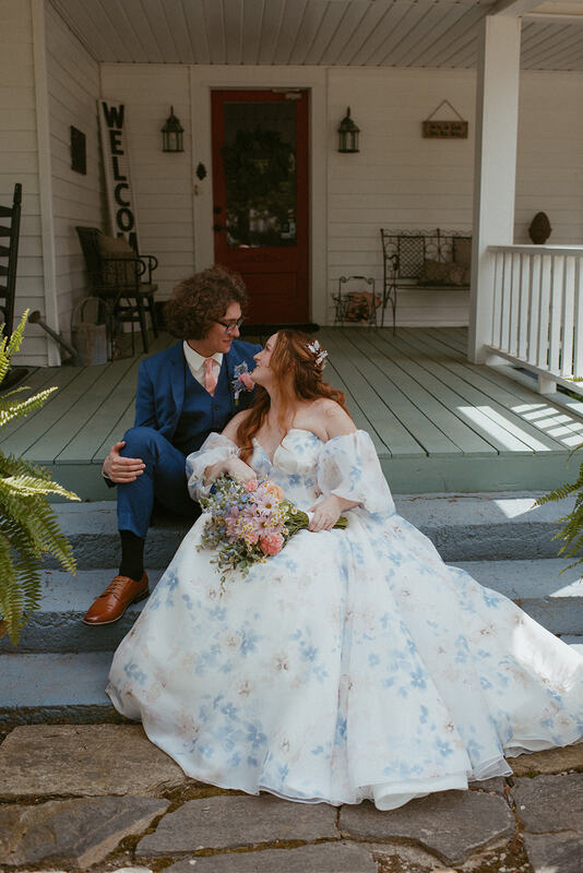 bride and groom sit on farmhouse front porch