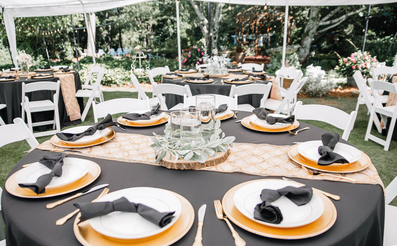 black and gold table decor under tent