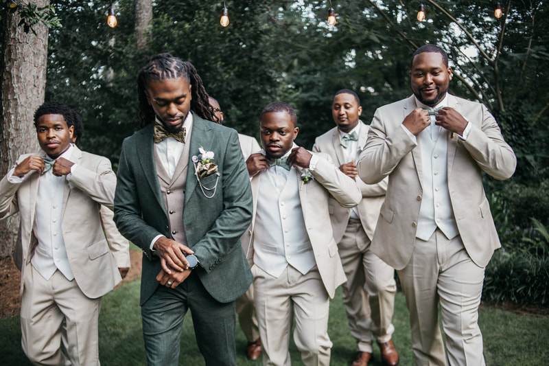groom and groomsmen fixing attire while walking