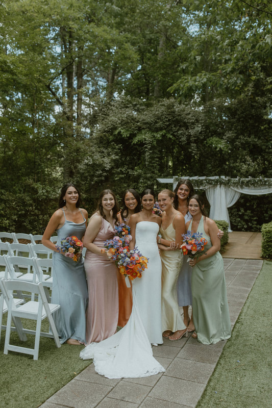 satin pastel bridesmaids at colorful floral bouquet